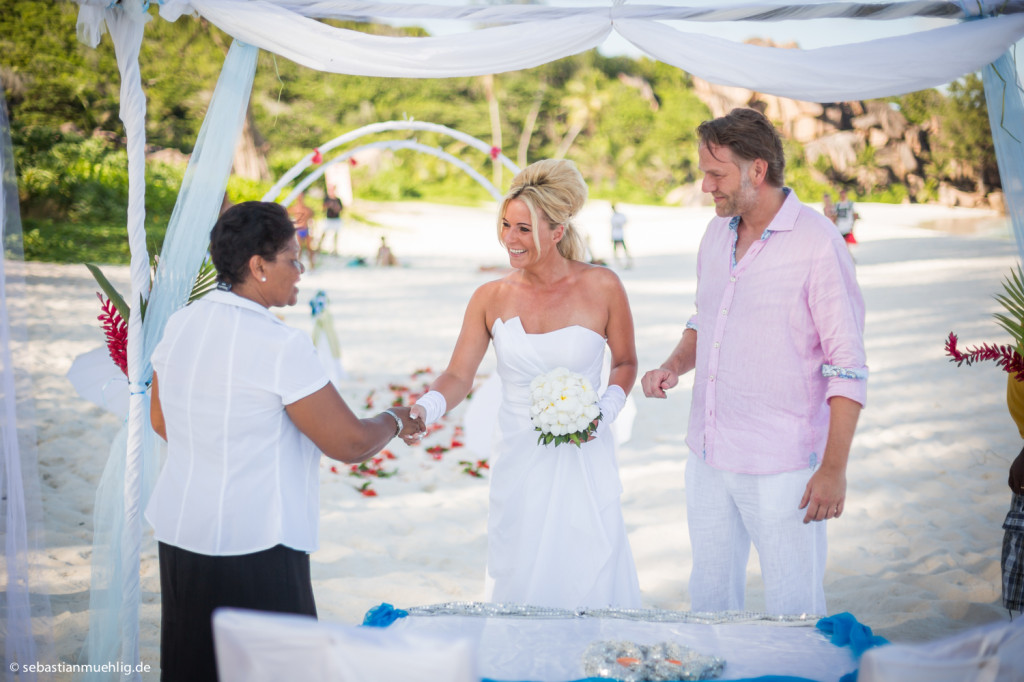 Trauung am Strand von La Digue mit Brautpaar und weißen Tüchern